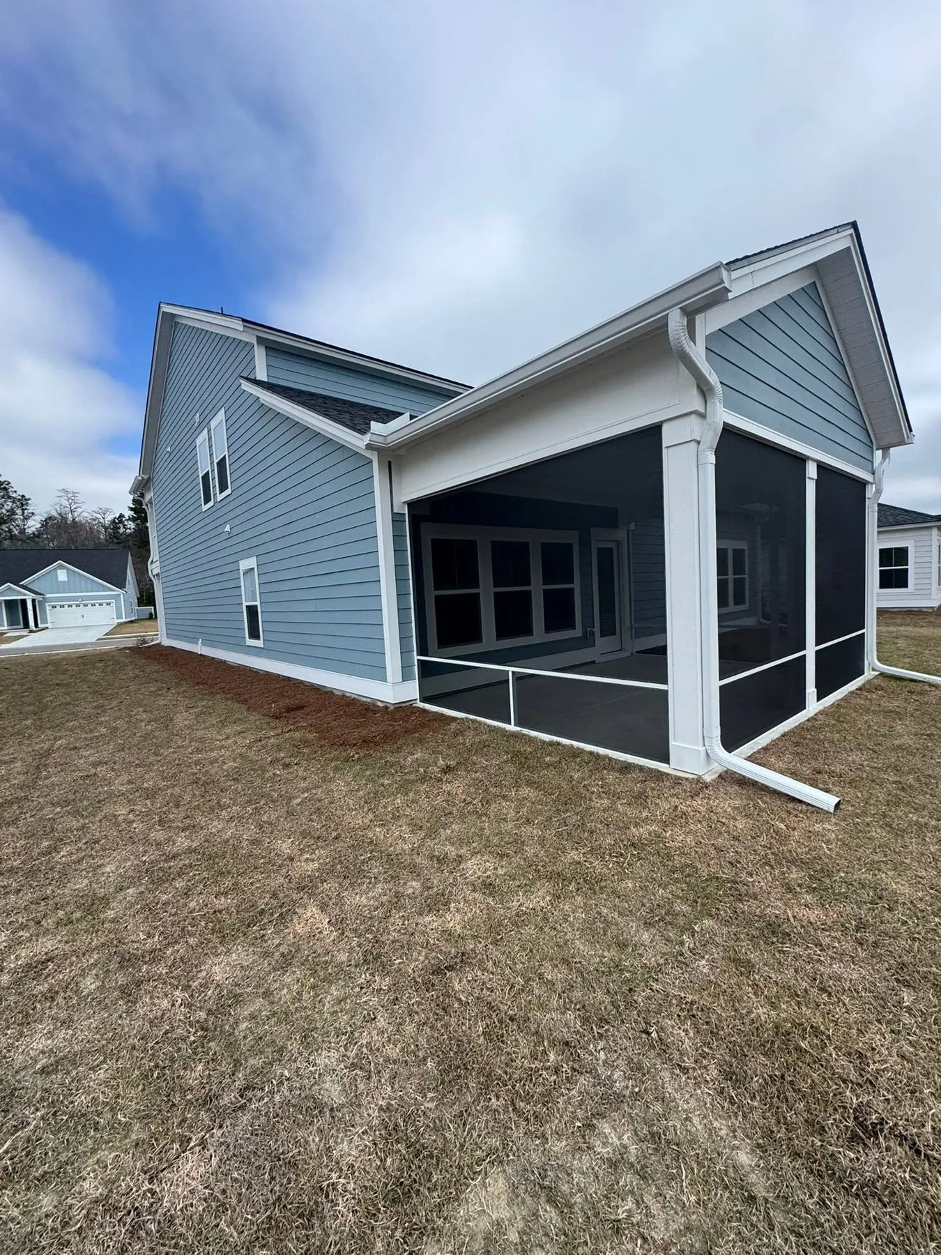 Gutters along a screened rear porch on a blue two-story home