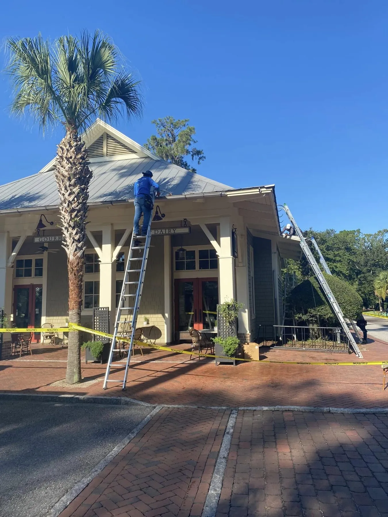 Crew member on a ladder working on a gutter run