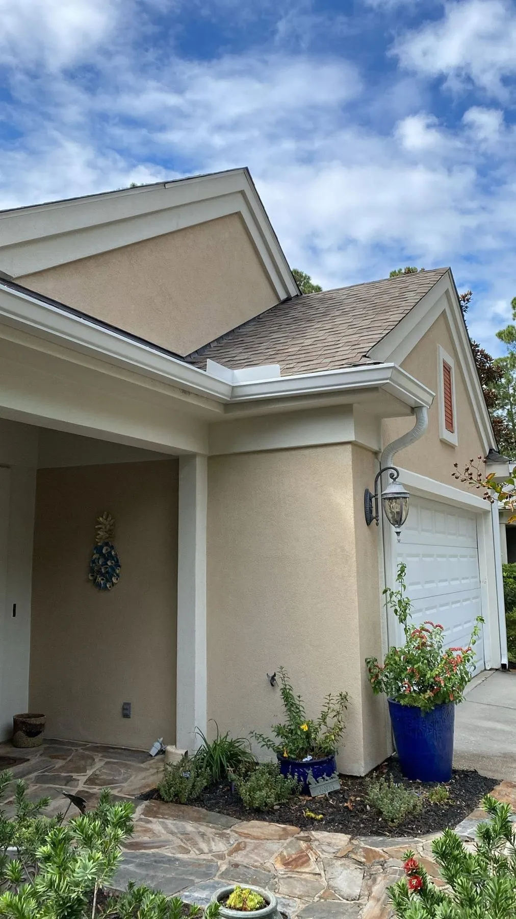 Stucco home with gutters above the garage